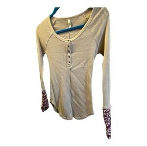 Tan shirt with maroon and white design on sleeves